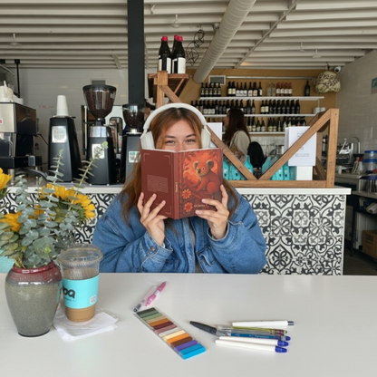 Astrobook personnalisé – femme cliente lisant un livre d’astrologie avec couverture koala dans un café