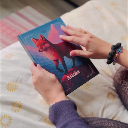 Démonstration de l’Astrobook Plumastro : une jeune femme feuillette un livre d’astrologie personnalisé avec thème astral, planètes et animal totem sur la couverture.