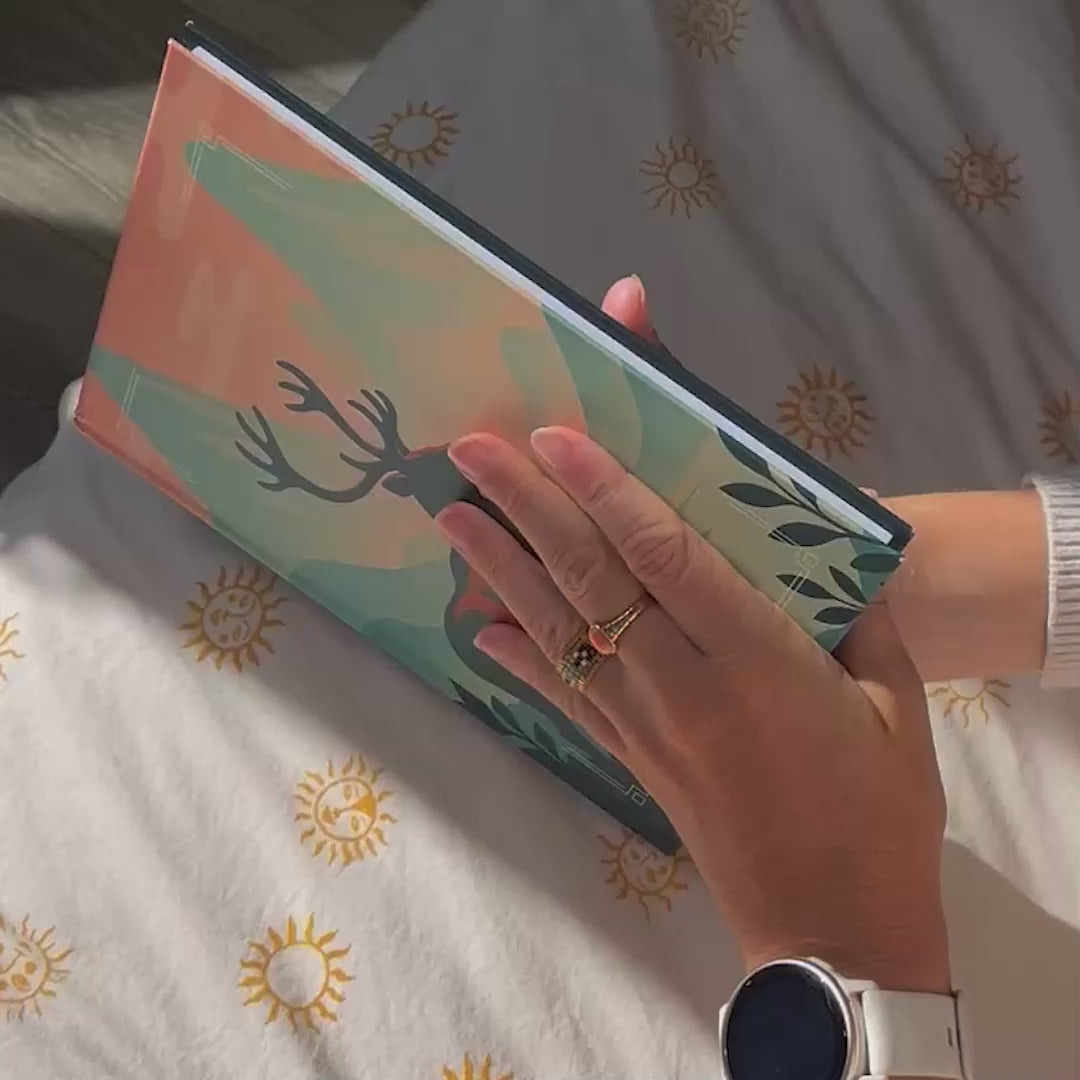 Démonstration de l’Astrobook Plumastro : une jeune femme feuillette un livre d’astrologie personnalisé avec thème astral, planètes et animal totem sur la couverture.